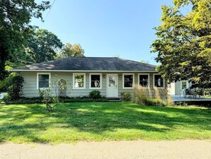 A single-story house with a front porch, a small front yard, and a visible garage door.