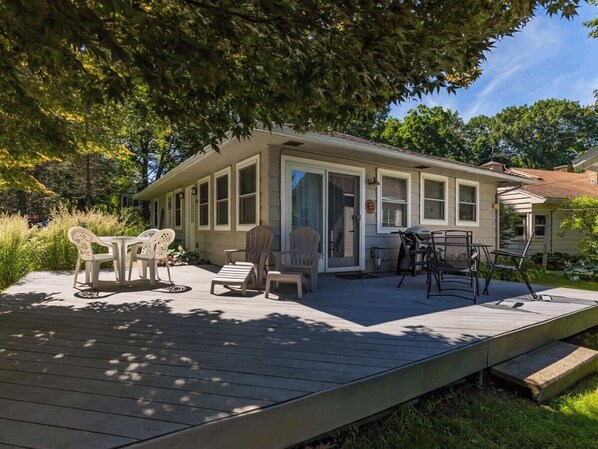 A house with a covered patio area featuring outdoor furniture and a small table.