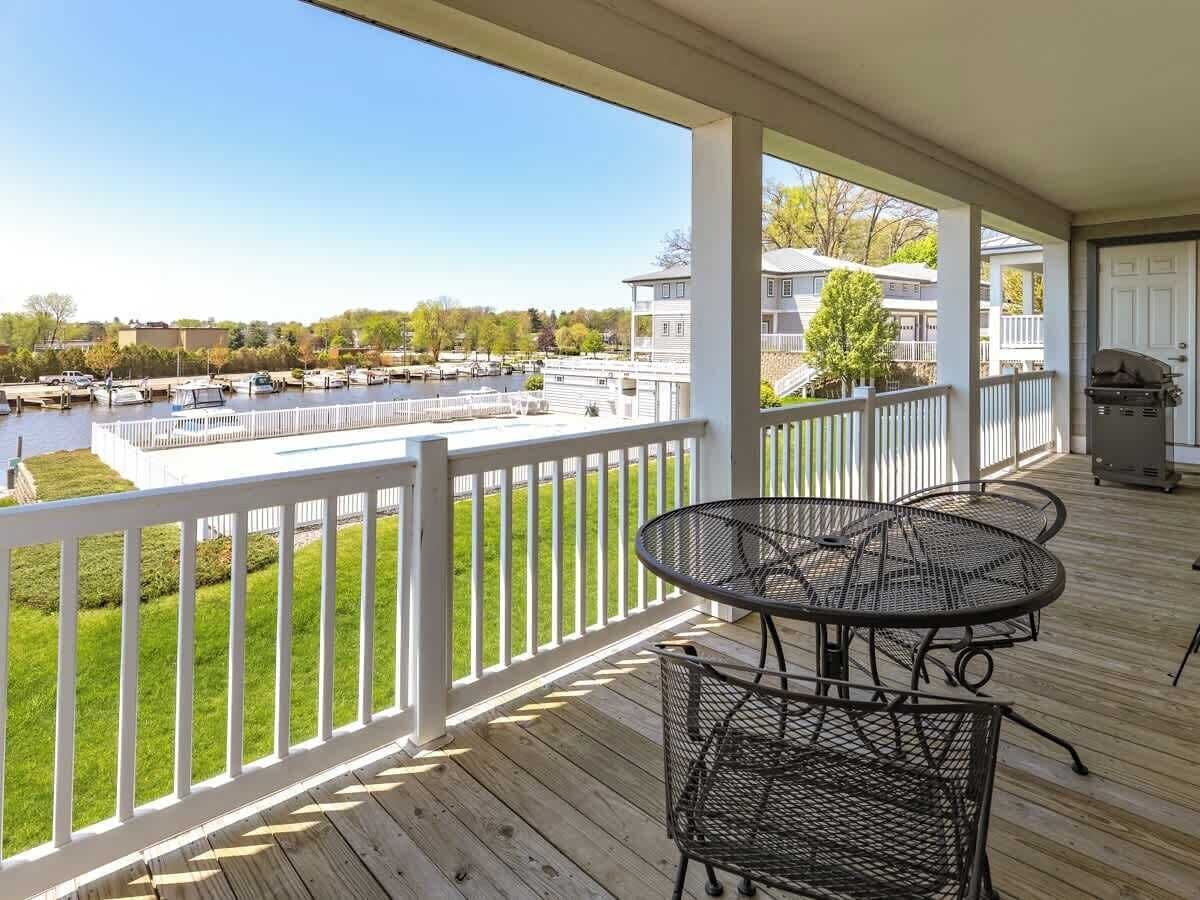 A covered outdoor deck with a view of a marina and houses.