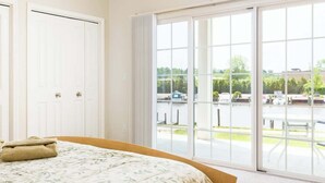 Hotellihuone, jossa on suuri sänky, ikkuna, josta avautuu näkymä parkkipaikalle ja viheralueille.
