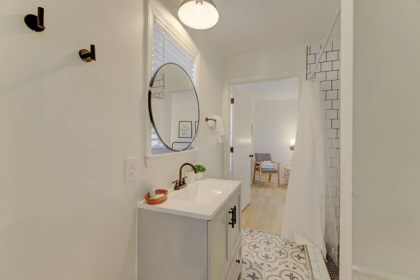 Un baño moderno con un lavabo blanco, un espejo y una zona de ducha.