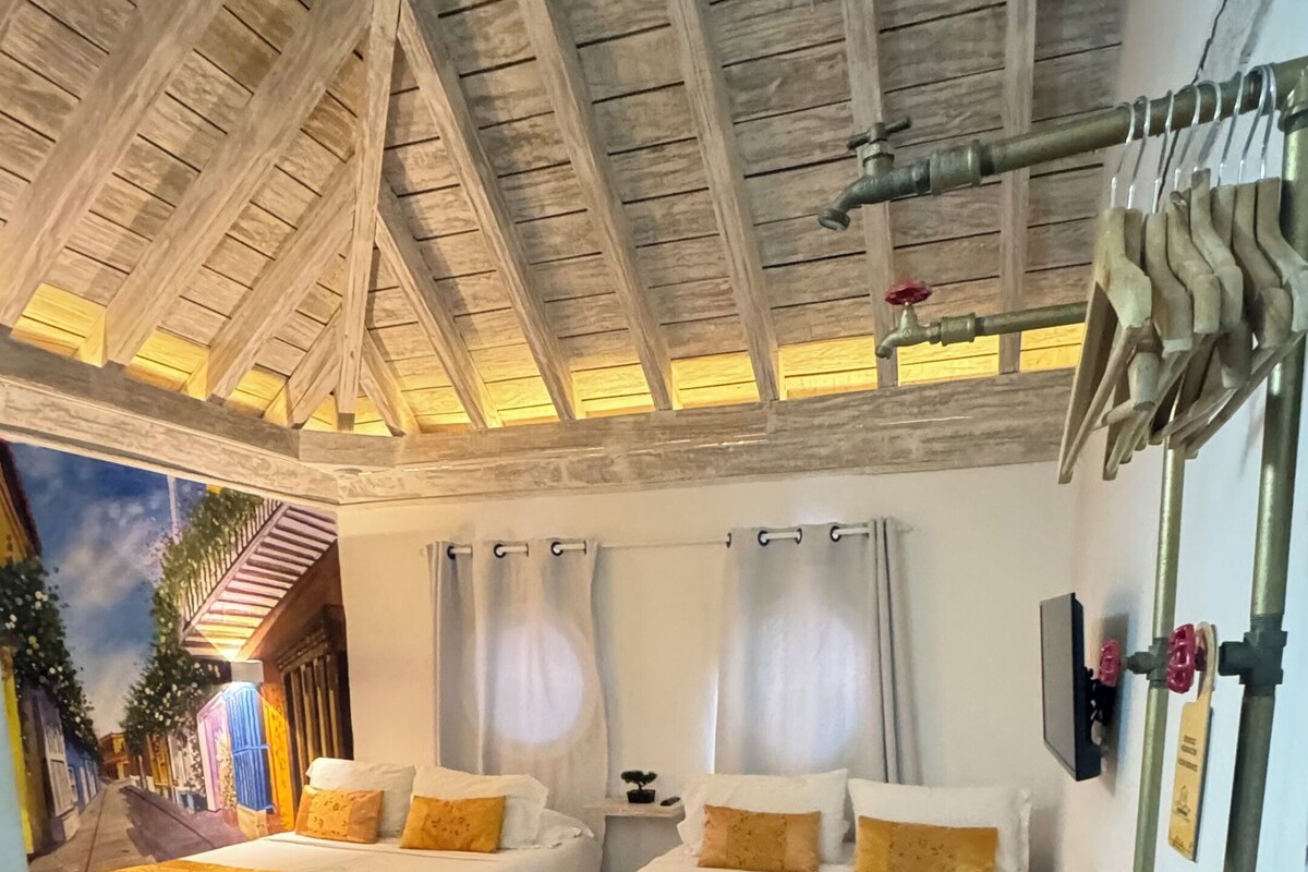 Une chambre avec deux lits, un plafond en bois et une vue sur la rue.