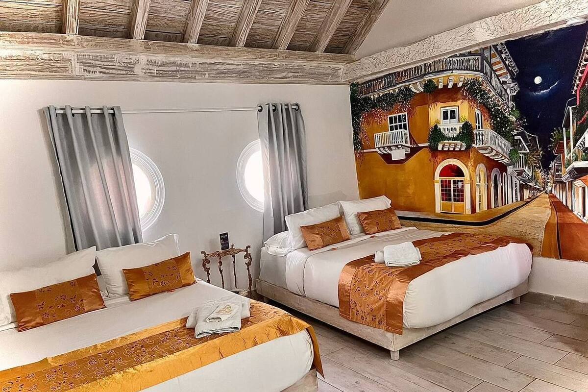 Camera d'albergo con due letti, un murale raffigurante una scena di strada e un soffitto in legno.