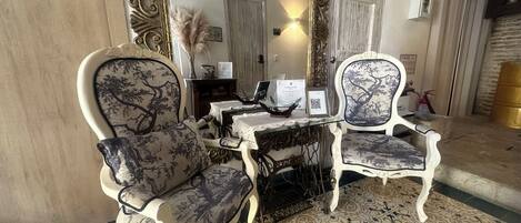 A room with ornate furniture, a patterned floor, and a mirror reflecting the room's interior.