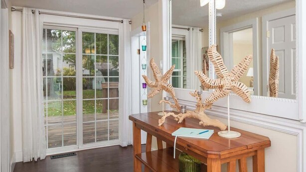 A wooden console table with a mirror, starfish decor, and a green vase. - Beach Grass, 2 BR, South Haven, Walk to the Beach (South Haven)