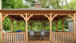 A wooden gazebo with a covered patio, two chairs, and a small table. - Isabel • walk to beach & downtown South Haven (South Haven)