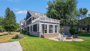 A two-story house with a covered porch and a fire pit in the backyard.