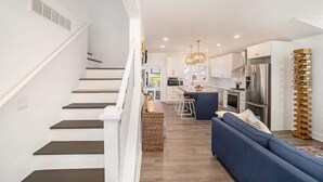 A modern kitchen with a central island, stainless steel appliances, and a wine rack. - SH Cottage (South Haven)