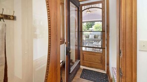 A wooden door with glass panels and a black doormat. - The Purple House (South Haven)