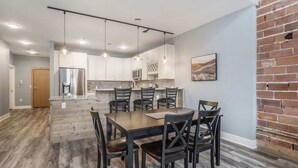 A modern kitchen with white cabinets, a central island, and pendant lighting.