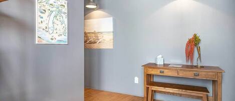 A room with a wooden desk, a bench, a map of Michigan, and two pendant lights.