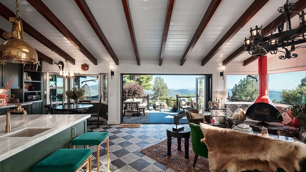 Un'ampia cucina con una grande isola, un'area pranzo con vista e un angolo salotto accogliente con camino.