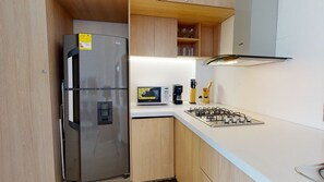 A compact kitchen with a stainless steel refrigerator, a microwave, and a gas stove. - Amazing APT  with incredible view-CENTRO HISTÓRICO - 511 (Cartagena de Indias)