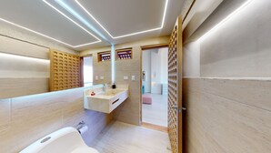 Un bagno moderno con uno specchio grande, una vasca e un mobile lavabo.