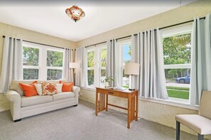 Relax in this spacious living room with a sofa, side table, and chair, perfect for unwinding.