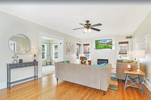 Relax in this inviting living room with a sofa, console table, and fireplace.