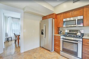 Enjoy cooking in this well-equipped kitchen with a refrigerator, microwave, stove, and oven, and dine at the adjacent table.