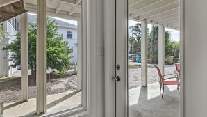 Un espacio de patio cubierto con vistas a un barrio residencial, con casas y árboles.
