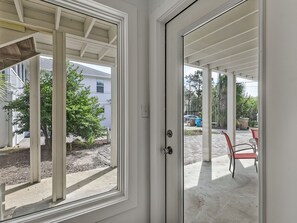 Un patio abrité offrant une vue sur un quartier résidentiel, avec ses maisons et ses arbres.