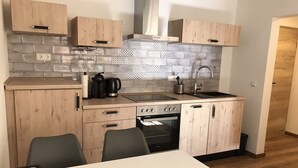 A modern kitchen with wooden cabinets, a built-in oven, and a sink.