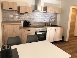 Een koelkast, een oven, een kookplaat, een vaatwasser