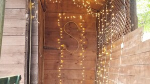 A wooden cabin with a rustic interior, featuring a wooden door with a rope decoration and string lights. - Olimbera Köy Evi (Arhavi)