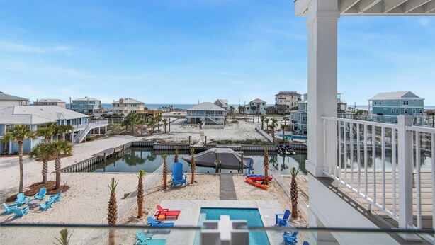 A beachfront property with a pool, beach chairs, and a dock. - Blue Chair | 🚤 Boater’s Paradise | Pool | Dock | Outdoor Bar | Pet Friendly 🐾 (Navarre)