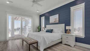 A bedroom with a bed, a bench, a nightstand, and a ceiling fan. - Blue Chair | 🚤 Boater’s Paradise | Pool | Dock | Outdoor Bar | Pet Friendly 🐾 (Navarre)