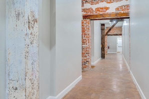 A hallway with exposed brick walls and a polished concrete floor.