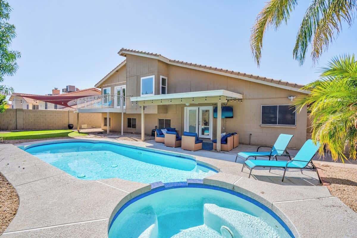 A two-story house with a swimming pool, outdoor seating, and a covered patio area.