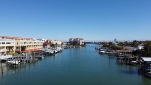 A marina with boats docked, a clear sky, and buildings along the water. - Anchors UP #1; WALK to Beach/Bars/Dining (Clearwater)