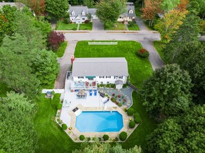 Relax by the large rectangular pool surrounded by lush greenery and mature trees on this serene property.