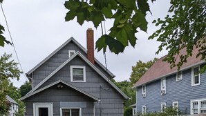 A residential house with a front yard, a patio with chairs, and a grill. - 2-bedroom in quiet neighborhood -- monthly rental perfect for traveling workers! (St. Joseph)