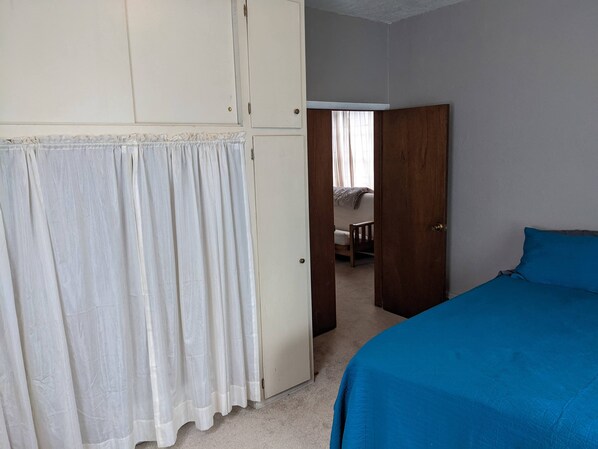A bedroom with a bed, a wardrobe, and a door leading to another room. - 2-bedroom in quiet neighborhood -- monthly rental perfect for traveling workers! (Saint Joseph)