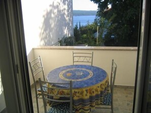 Enjoy a peaceful moment on this balcony with a scenic view of the water and lush surroundings.