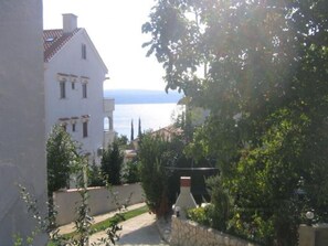 Situated in a lush environment, this residence offers a balcony with a view of the sea.