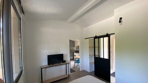 A hotel room with a bed, a desk, a chair, and a TV. - Charming Guesthouse with view to countryside and Mont Ventoux (Entrechaux)