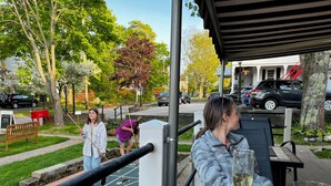 A restaurant patio with outdoor seating, a hopscotch game, and a view of the street. - Queen Anne's Revenge (Bar Harbor)
