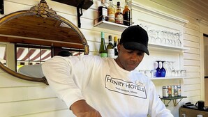 A person pouring a drink from a bottle into a glass. - Queen Anne's Revenge (Bar Harbor)