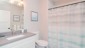 Une salle de bain équipée d’un lavabo, de toilettes et d’un rideau de douche.