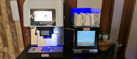 A coffee machine and a small refrigerator on a wooden table.