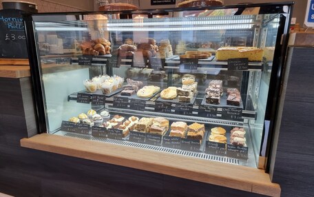 A bakery display case with various baked goods and desserts.