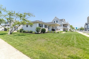 A two-story house with a front porch, a driveway, and a well-maintained lawn. - Bay-View Bungalow, Dogs Welcome, Parking — Sleeps 9, Single Level (Ventnor City)