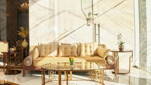 A modern living room with a beige sofa, round glass coffee table, and decorative vases. - Carlton Dubai Creek (Dubai)