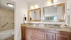 A bathroom with a double sink vanity, a shower with a grab bar, and two mirrors with gold frames. - Wonderful Apt Hotel with Pool in Kissimmee 5 (Kissimmee)