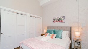 Una camera da letto con un letto, due comodini, una testiera e un quadro appeso al muro.