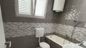 A bathroom with a toilet, a bathtub, and a sink. - Apartments Roko - One bedroom apartment with balcony and sea view (A2) (Sveti Filip i Jakov)