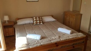 A bedroom with a wooden bed, a nightstand, a dresser, and a framed picture on the wall. - Apartments Roko- One bedroom apartment with balcony and sea view (B3) (Sveti Filip i Jakov)