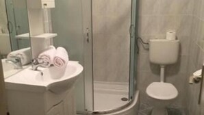 A bathroom with a glass-enclosed shower, a white sink with a mirror, and a toilet. - Apartments Roko- One bedroom apartment with balcony and sea view (B3) (Sveti Filip i Jakov)