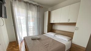 Ein Schlafzimmer mit einem großen Bett, einem Holzkopfende und einem Kleiderschrank.